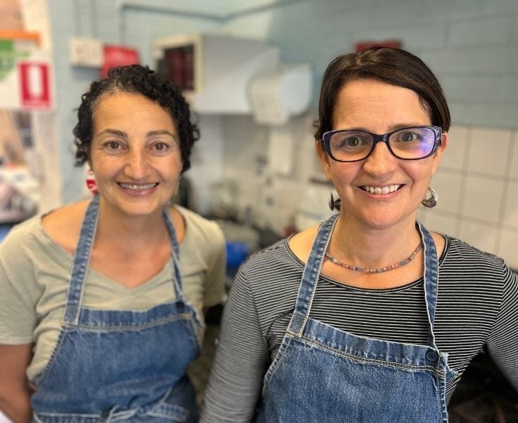 Two Canteen volunteers with denim aprons